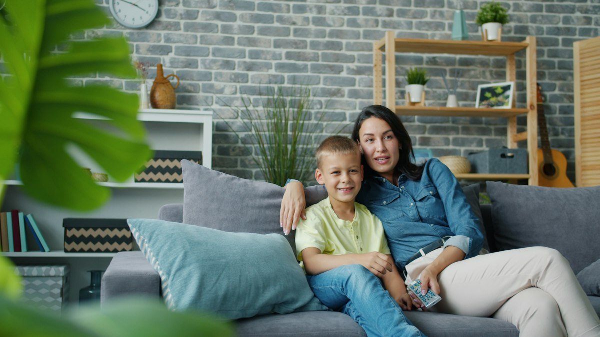Mother and son watching TV together on the couch